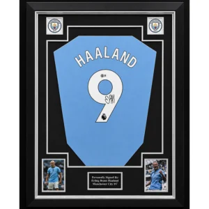 Erling Braut Haaland – Gesigneerd Manchester City Shirt | Professioneel Ingelijst & Gecertificeerd Een exclusief verzamelstuk van één van de meest dominante spitsen van het moderne voetbal: Erling Braut Haaland. Dit Manchester City-shirt is persoonlijk gesigneerd door Erling Haaland en professioneel verwerkt in een luxe memorabilia-display. Een indrukwekkend collectors item dat de kracht, doelgerichtheid en ongekende prestaties van de Noorse topspits perfect weerspiegelt. Een doelpuntenmachine van wereldklasse Erling Braut Haaland heeft zich in recordtempo ontwikkeld tot één van de meest gevreesde aanvallers ter wereld. Met zijn uitzonderlijke fysieke kracht, snelheid en fenomenale scorend vermogen brak hij direct na zijn komst naar Manchester City talloze records. Tijdens zijn periode bij Manchester City groeide Haaland uit tot één van de absolute sterren van de Premier League en speelde hij een sleutelrol in het winnen van onder andere de Premier League, de FA Cup en de UEFA Champions League. Zijn prestaties hebben hem een vaste plaats bezorgd tussen de grootste spitsen van zijn generatie. Dit gesigneerde Manchester City-shirt is een eerbetoon aan een speler die het moderne voetbal blijft domineren. Gesigneerd & gecertificeerd Het shirt is persoonlijk gesigneerd door Erling Braut Haaland en wordt geleverd met een certificaat van echtheid. Daarnaast is het professioneel ingelijst met hoogwaardige materialen om het shirt optimaal te presenteren én te beschermen. Hierdoor is het direct klaar om een prominente plaats te krijgen in een collectie, kantoor, mancave of andere bijzondere ruimte. Productkenmerken: Manchester City voetbalshirt Persoonlijk gesigneerd door Erling Braut Haaland Inclusief certificaat van echtheid Professioneel en luxe ingelijst Premium voetbalmemorabilia Exclusief display- en verzamelobject Direct klaar om tentoongesteld te worden Een premium collectors item Gesigneerde memorabilia van Erling Braut Haaland behoren tot de meest gewilde verzamelobjecten binnen het moderne voetbal. Dit professioneel ingelijste Manchester City-shirt combineert exclusiviteit, authenticiteit en een luxe presentatie in één indrukwekkend display. Een premium verzamelstuk voor liefhebbers van Erling Braut Haaland, Manchester City en exclusieve voetbalmemorabilia. Een doelpuntenmachine. Een iconische handtekening. Een blikvanger voor iedere voetbalcollectie.